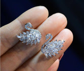 Swan Crystal Earrings showcased in a hand, featuring sparkling cubic zirconia and an elegant swan design.